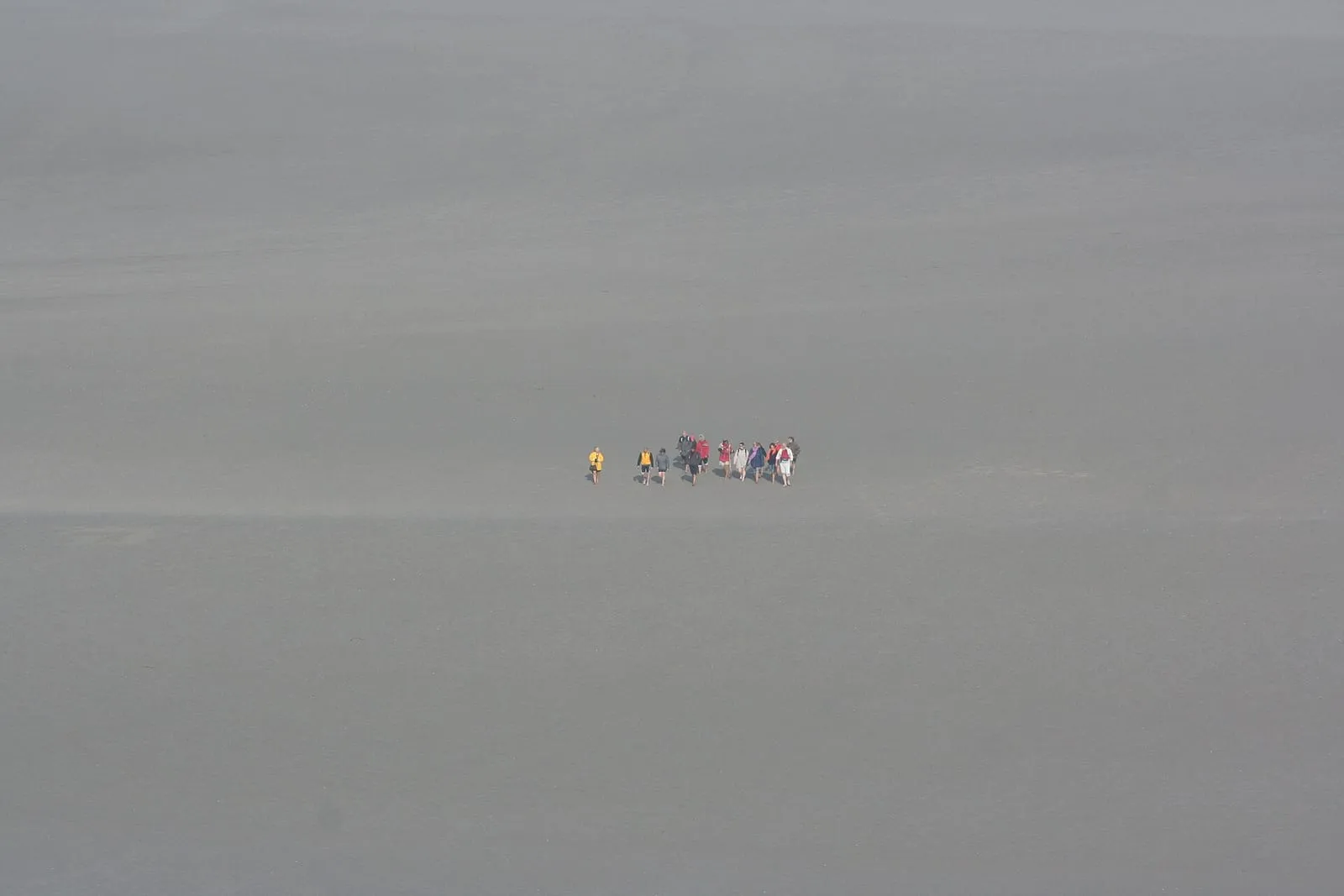Walkers crossing the sands of the bay of Mont-Saint-Michel